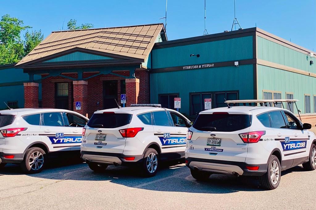 Three U N E security vehicles lined up outside the Safety 和 Security building