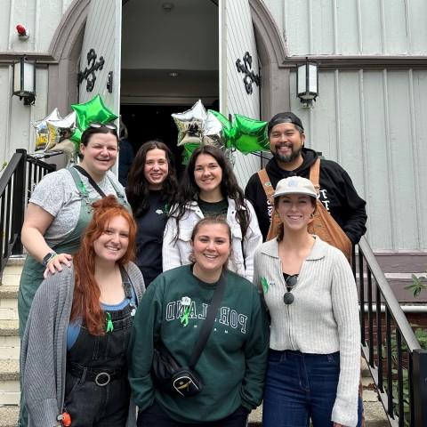 A group of UNE students poses in front of UNE's Ludcke Auditorium 